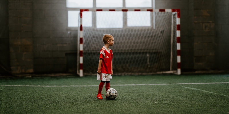 A child next to a soccer ball - football and soccer history facts